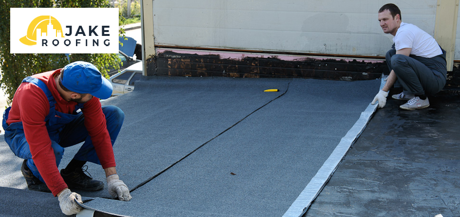 Workers installing roof patch on pitched roof